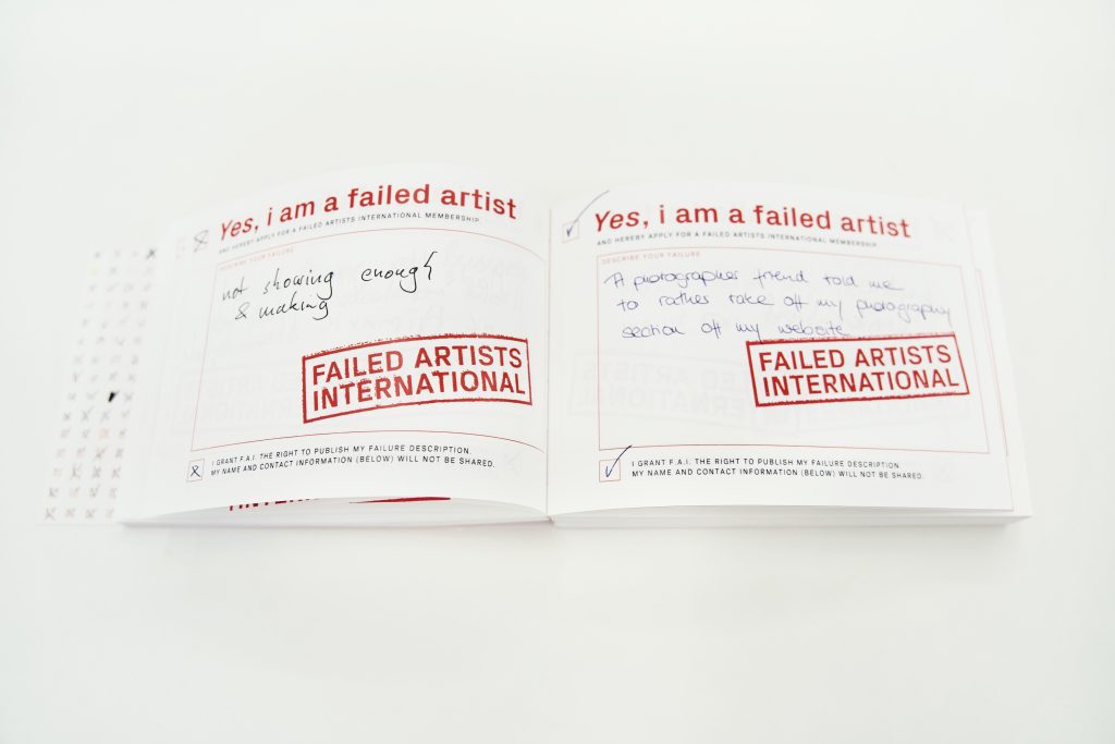 Photo of the book "FAILED ARTISTS INTERNATIONAL" openend on a table.